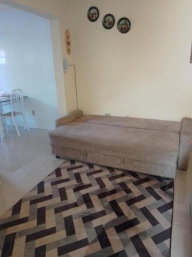 a bed in a room with a rug on the floor at Arbricot in Rio das Ostras