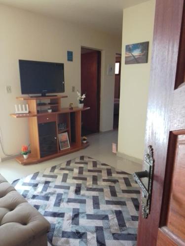 a living room with a couch and a television at Arbricot in Rio das Ostras