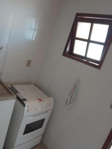 a small kitchen with a window and a sink at Arbricot in Rio das Ostras