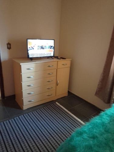 a bedroom with a dresser with a television on it at Arbricot in Rio das Ostras