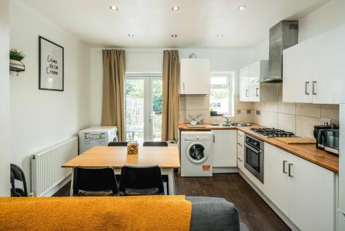 a kitchen with a wooden table and a counter top at Lovely 3 bed house in Feltham in Feltham