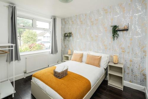 a bedroom with a bed and a window at Lovely 3 bed house in Feltham in Feltham