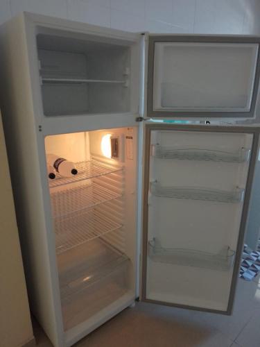a white refrigerator with its door open and its door at Arbricot in Rio das Ostras
