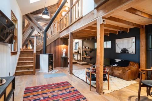 a large living room with wooden ceilings and wooden beams at Chic Catskills Cabin with Hot Tub and Fire Pit in Lanesville