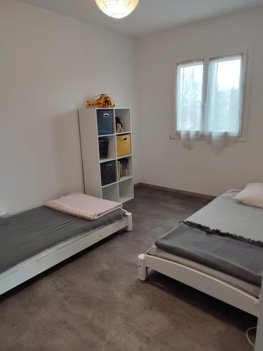 une chambre avec deux lits et une étagère dans l'établissement Mas Boucard Terrasse et parking privés, à Frontignan