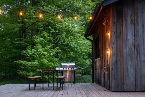 a patio with two chairs and a grill on a cabin at Chic Catskills Cabin with Hot Tub and Fire Pit in Lanesville