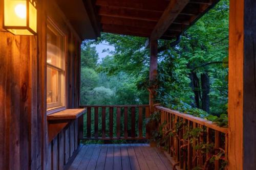 a porch of a cabin with a view of a forest at Chic Catskills Cabin with Hot Tub and Fire Pit in Lanesville