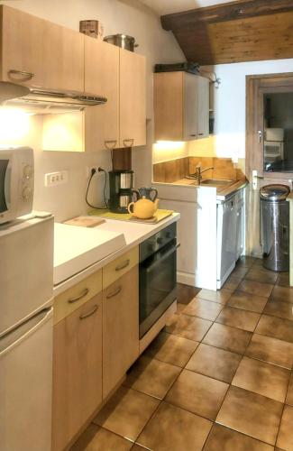 une grande cuisine avec des armoires et des appareils blancs dans l'établissement Maison pittoresque à Sainte-Croix-aux-Mines, vue sur la montagne, à Sainte-Croix-aux-Mines