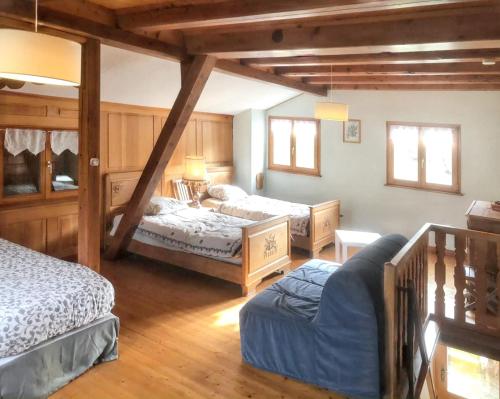 a bedroom with two beds and a couch in it at Maison pittoresque à Sainte-Croix-aux-Mines, vue sur la montagne in Sainte-Croix-aux-Mines