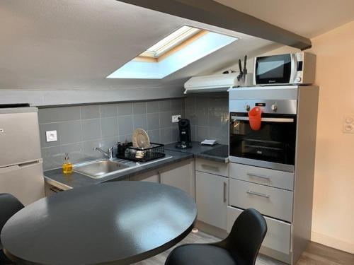 La cuisine est équipée d'une table, d'un évier et d'un four micro-ondes. dans l'établissement Studio Tuco, à Mont-de-Marsan