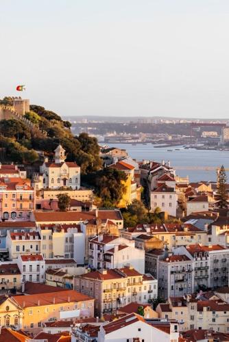 a group of buildings on a hill next to the water at Comtesse Lisbonne Guest House by Homing in Lisbon