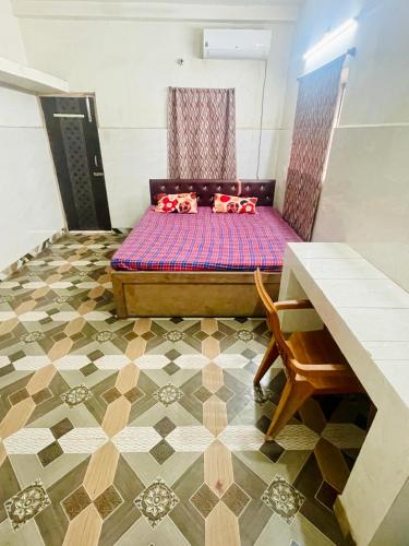 a bed sitting in a room with a floor at Om Guest House in Patna