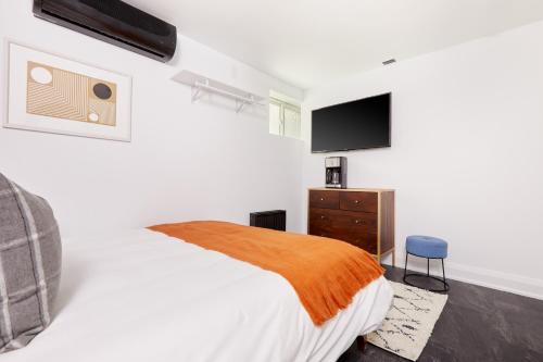 a bedroom with a bed and a flat screen tv at La TUMU in Toronto