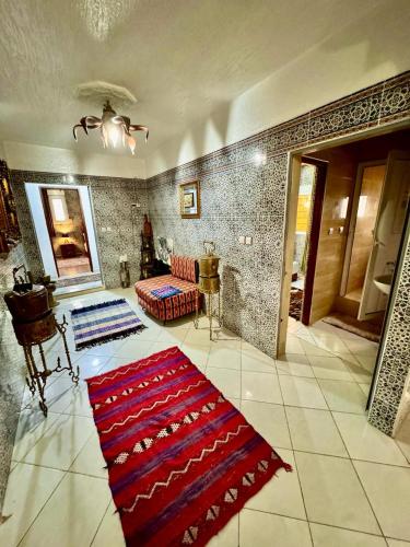 a living room with a red rug on the floor at Auberge Sous Les Étoiles Lac Ouiouane in Kasba des Aït Athmane