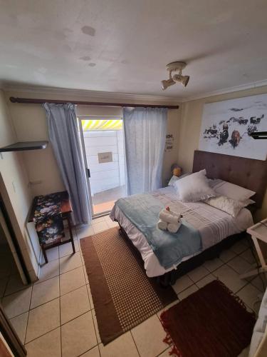 a bedroom with a bed with a teddy bear on it at Durbanville CPT Pet Friendly, Self-Catering in Oakdale