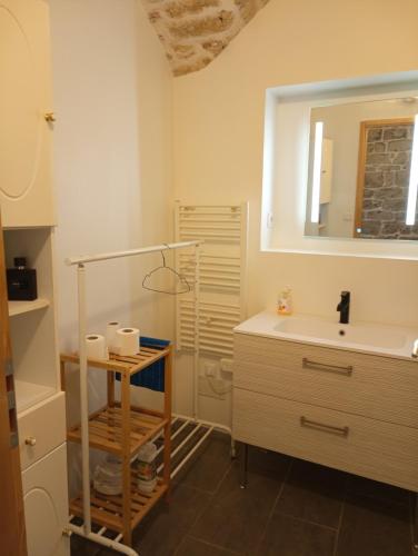 une salle de bain avec un lavabo et un miroir dans l'établissement Appartement de charme, à Cournonterral
