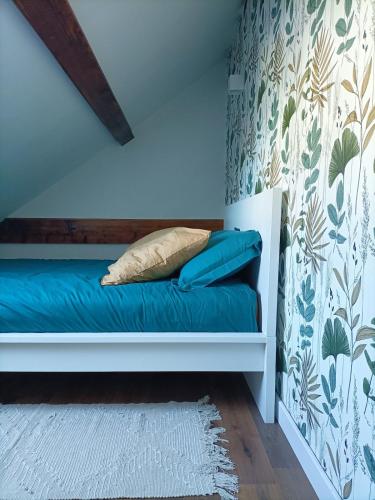 - une chambre dotée d'un lit avec des draps bleus dans l'établissement Le pied-à-terre des bains, à Aix-les-Bains