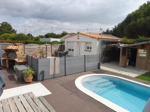 une cour arrière avec une piscine et une maison dans l'établissement La petite maison studiot, à Pornic