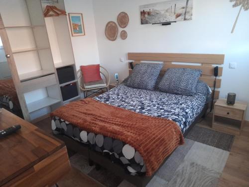 een slaapkamer met een bed en een stoel bij La petite maison studiot in Pornic