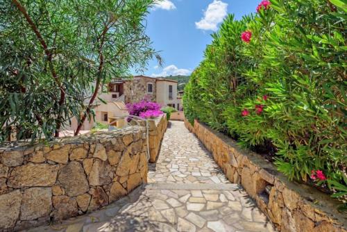 a stone path in a garden with flowers and plants at Appartamento pittulongu in Olbia