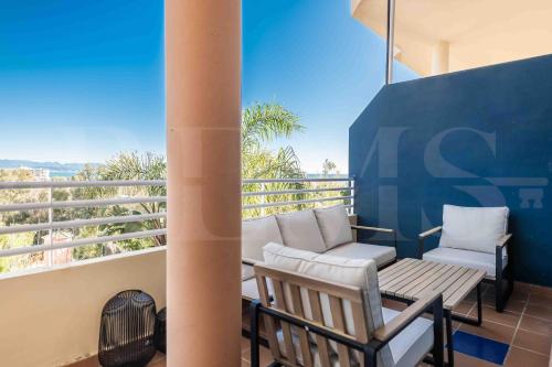 a balcony with two chairs and a bench on a balcony at Premium villa with private pool & garden by REMS in Torremolinos