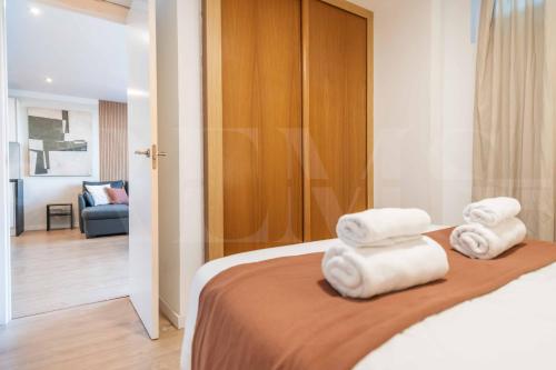 a room with a bed with white towels on it at Premium villa with private pool & garden by REMS in Torremolinos