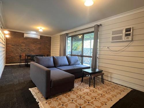 a living room with a couch and a table at Cute Cottage Home - Vintage Charm & Great Location at Slacks Creek, Close to Logan Central & M1 in Slacks Creek