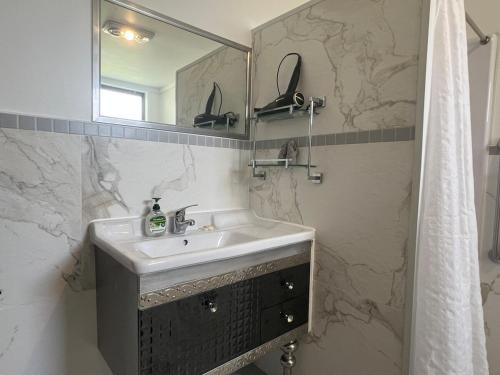 a bathroom with a sink and a mirror at Cute Cottage Home - Vintage Charm & Great Location at Slacks Creek, Close to Logan Central & M1 in Slacks Creek