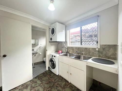 a kitchen with a sink and a washing machine at Cute Cottage Home - Vintage Charm & Great Location at Slacks Creek, Close to Logan Central & M1 in Slacks Creek