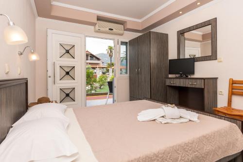 a bedroom with a bed with a mirror and a tv at Katerina Rooms & Apartments in Skala Potamias