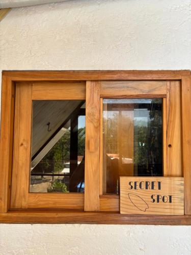 a wooden sign in a window with a sign for a special stop at La Chamba Surf House in Santa Catalina