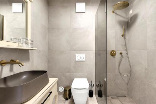 a bathroom with a shower and a toilet and a sink at Hotel Liberan - Nature's Retreat in Podgora