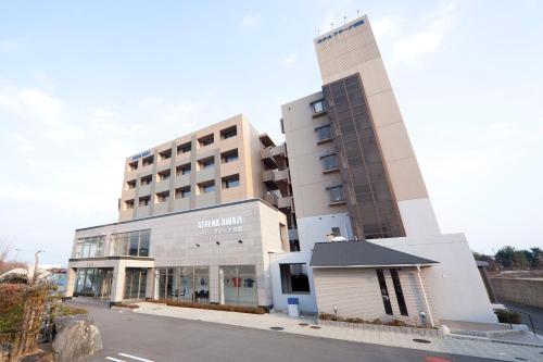 a building with a parking lot in front of it at Athena Kaigetsu in Awaji