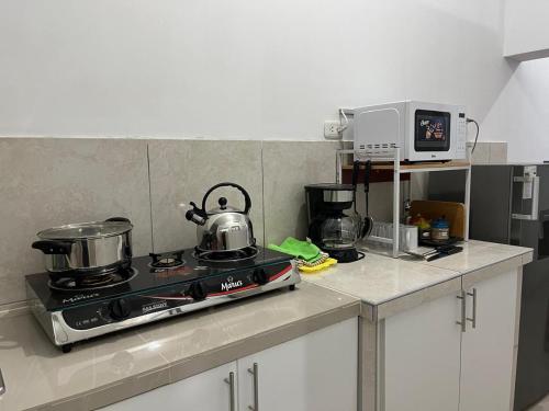 a kitchen with a stove with pots and pans on it at Albano apartamento 3 en tu refugio Chosica in Chosica