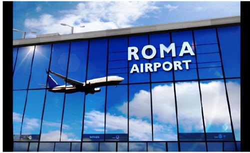 an airplane is flying reflected in the windows of a building at Luciana Apt - 3 min train to FCO Airport & Fiera in Fiumicino