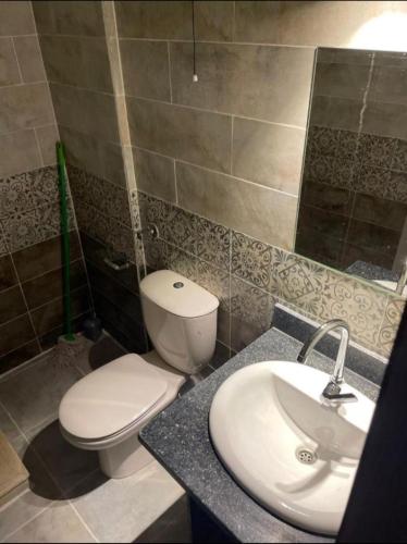 a bathroom with a white toilet and a sink at Royal residence in Marsa Alam