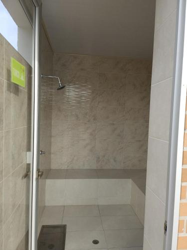 a shower with a glass door in a bathroom at Apartamento amoblado en Cucuta in Los Patios