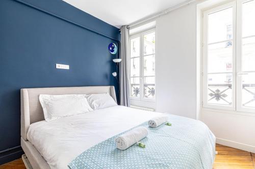 - une chambre bleue avec un lit et des serviettes dans l'établissement GuestReady - A lovely stay in Batignolles, à Paris