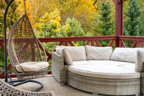 a porch with a couch and a swing at Villa Emausy in Luhačovice
