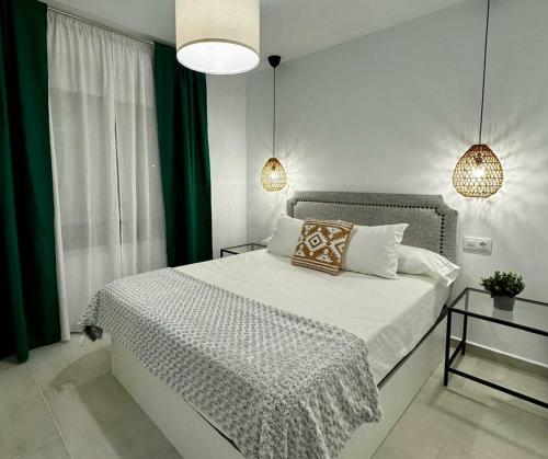 1 dormitorio con 1 cama grande con cortinas blancas y verdes en Apartamentos Muñoz Fornell 4, en Chiclana de la Frontera