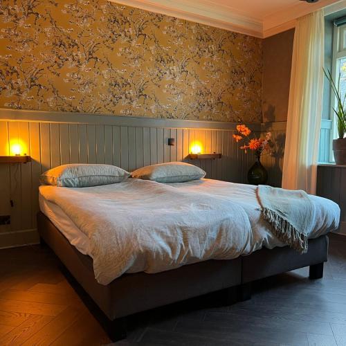 a bedroom with a large bed with two pillows at B&B Hartje Drenthe in Westerbork