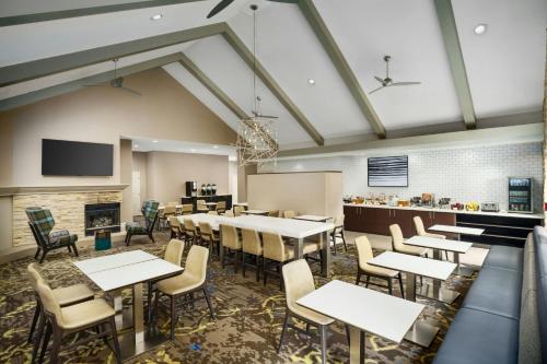 a dining room with tables and chairs and a fireplace at Residence Inn Dallas Addison/Quorum Drive in Dallas