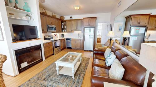 a living room with a leather couch and a fireplace at Beautiful Sunrise in Folly Beach