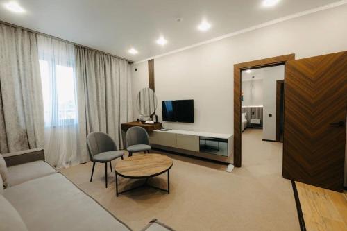 a living room with a couch and a table at Irislux in Taraz