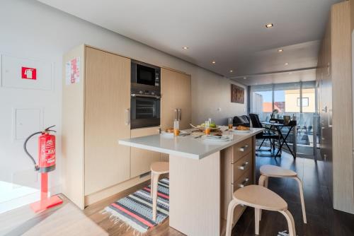 a kitchen with a counter and chairs in a room at H2O Apartment - Rooftop with pool in Santa Cruz in Santa Cruz