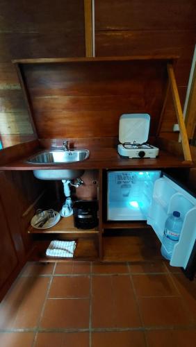 a bathroom with a sink and a counter with a tv at Roça Maria Helena-Príncipe in Santo António