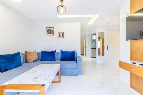 a living room with a blue couch and a table at Hot appar Luxury SuiteMar in M'diq