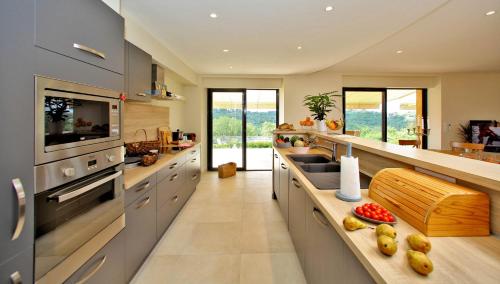 une grande cuisine avec des appareils en acier inoxydable et un comptoir dans l'établissement La Marquaysserie du Domaine de la Malonie, à Sarlat-la-Canéda