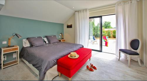 - une chambre avec un grand lit et un tabouret rouge dans l'établissement La Marquaysserie du Domaine de la Malonie, à Sarlat-la-Canéda