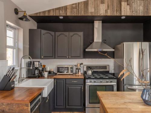 a kitchen with gray cabinets and a stove top oven at Private Cabin with Guesthouse Hot Tub Fire Pits in Roscoe